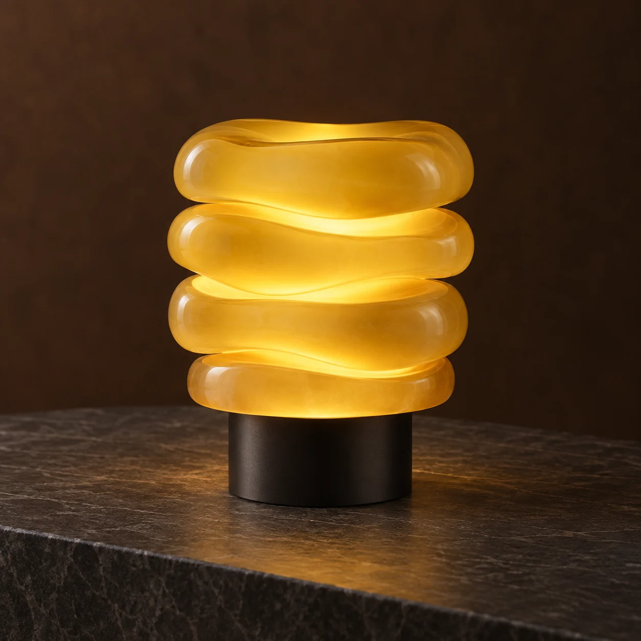 Yellow stacked sculptural lamp on a dark table